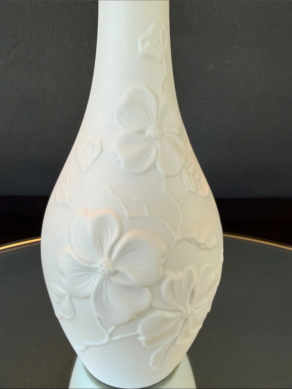 AK Kaiser White Bisque Porcelain Bud Vase featuring an embossed floral design.